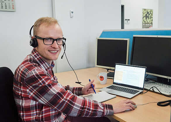 Erk Marten Schröder sitzt mit Headset vor seinem Notebook.