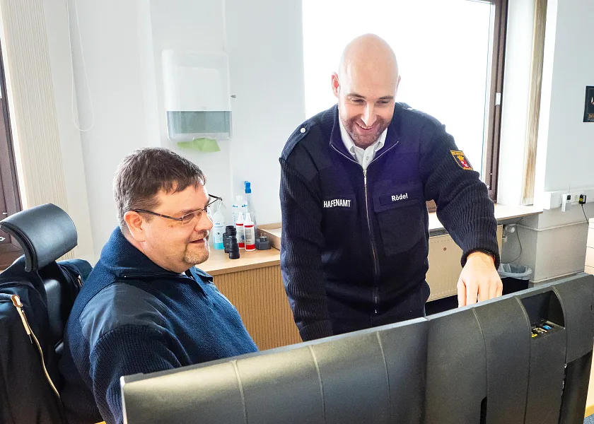 Nils Rödel (rechts) und Björn Greifenberger (links) schauen gemeinsam auf den Monitor eines Computers.