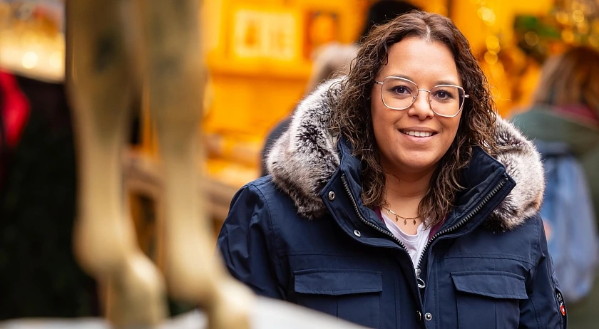 Sarah Roba vor erleuchteten Buden eines Marktes. Im Vordergrund sind die Vorderbeine des Esels der Bremer Stadtmusikanten zu sehen.