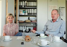 Kerstin Brockmüller und Jörg Meyer sitzen an einem Besprechungstisch.