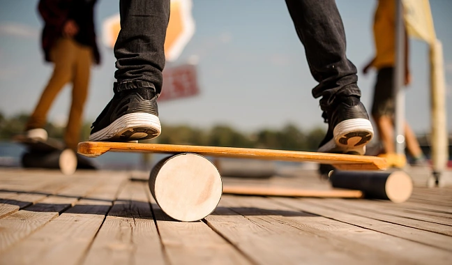 Nahaufnahme eines Balanceboards mit den Beinen und Füßen einer Person