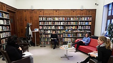 Krimibibliothek innerhalb der Stadtbibliothek Bremens, hier sitzen vier Personen mit Abstand, die ein Gespräch führen