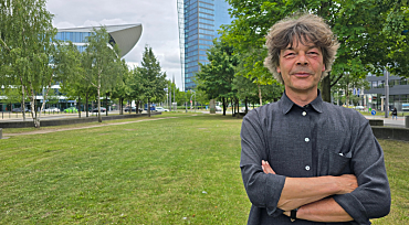 Stefan Wittig steht mit verschränkten Armen auf einer Wiese vor dem Dienstgebäude der Senatorin für Umwelt, Klima und Wissenschaft in der Bremer Überseestadt